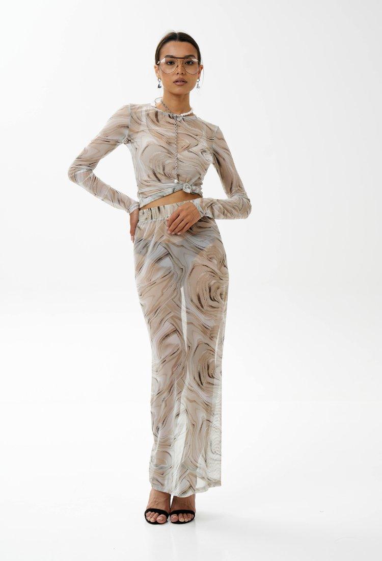 Tenue élégante à motifs marbrés, haut noué et pantalon long pour un style chic et moderne