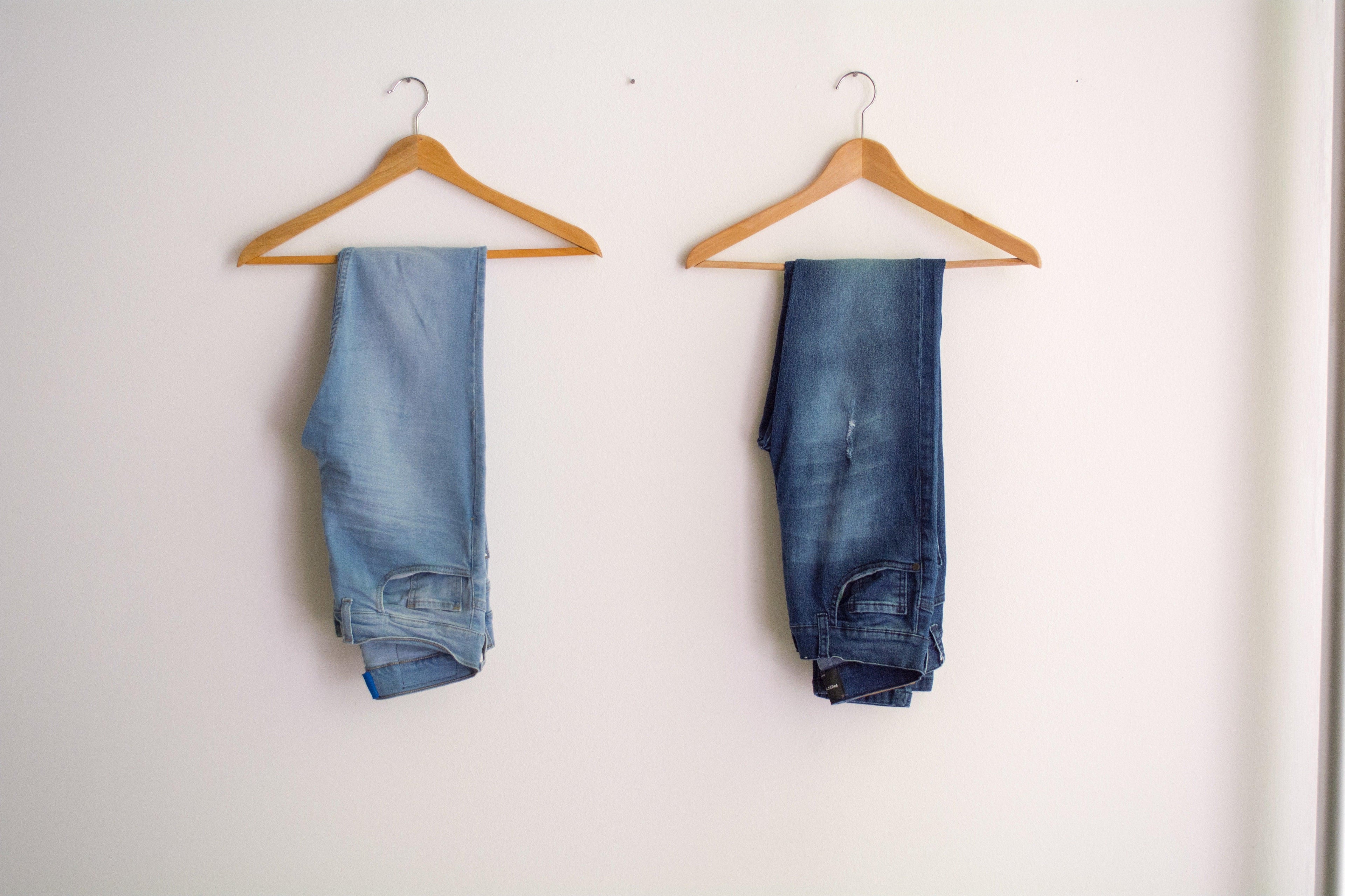 Deux jeans femme bleu clair et foncé sur cintres en bois, mode chic abordable
