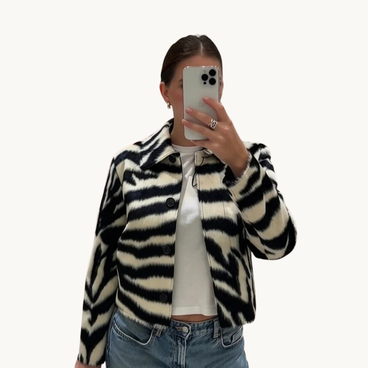 Veste zébrée courte portée ouverte sur un t-shirt blanc et un jean