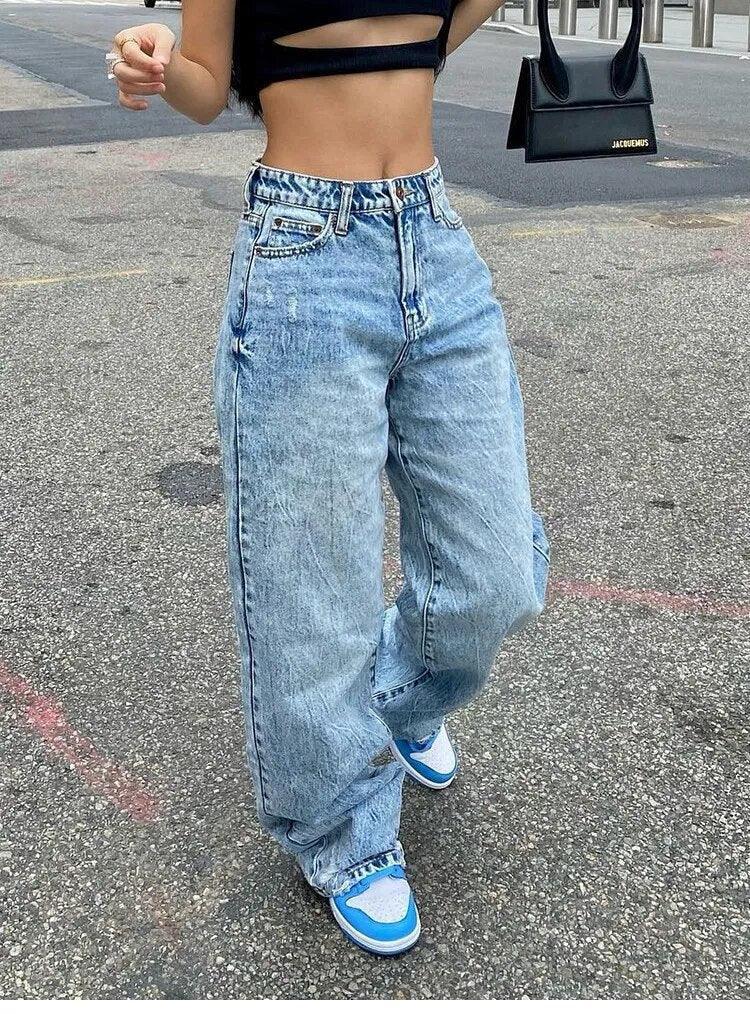 Jeans larges bleu clair, crop top noir et sneakers bleues, look streetwear chic