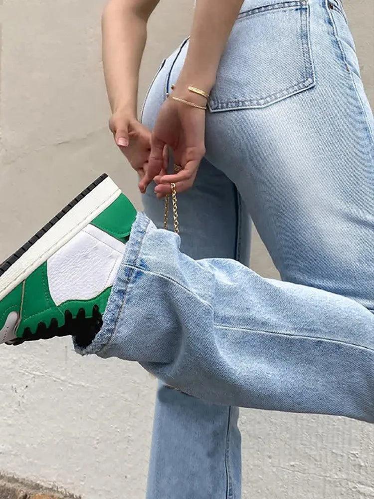 Jeans larges bleu clair et baskets vertes blanches, style mode féminine chic et décontracté