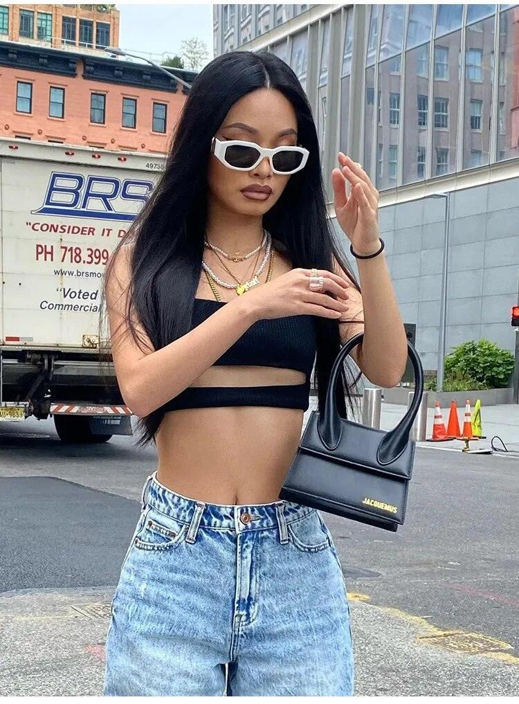 Femme en crop top noir et jean large, lunettes de soleil, style urbain chic