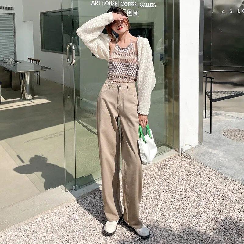Tenue chic femme : haut maille, pantalon large beige, cardigan blanc, sac à main vert et blanc