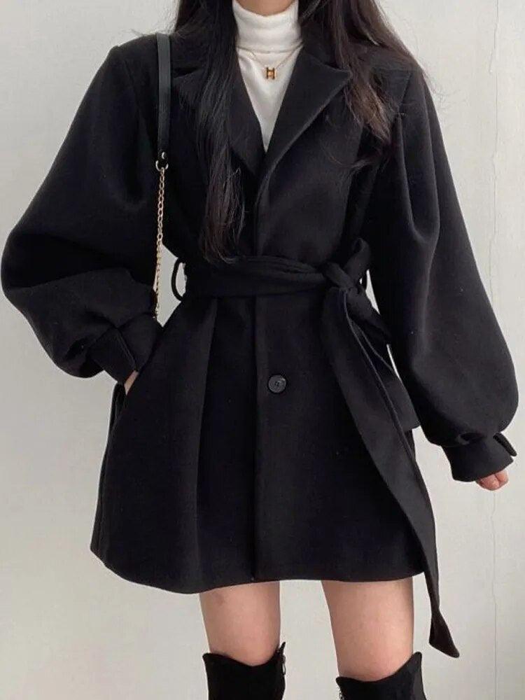 Manteau noir élégant à ceinture, manches bouffantes, pour look chic et tendance