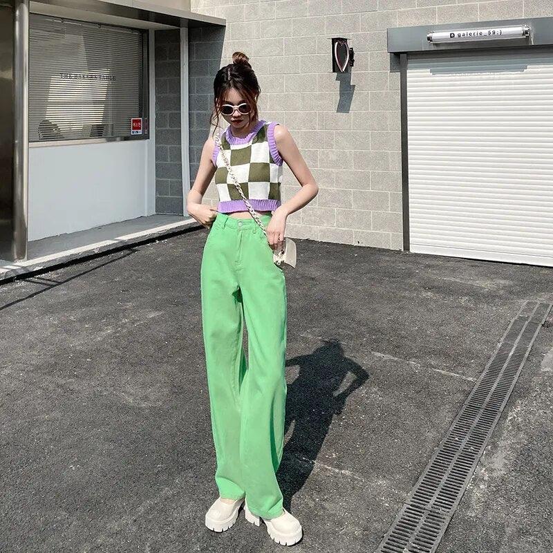 Tenue chic femme : haut à carreaux violet et vert, pantalon large vert, chaussures blanches, style urbain tendance